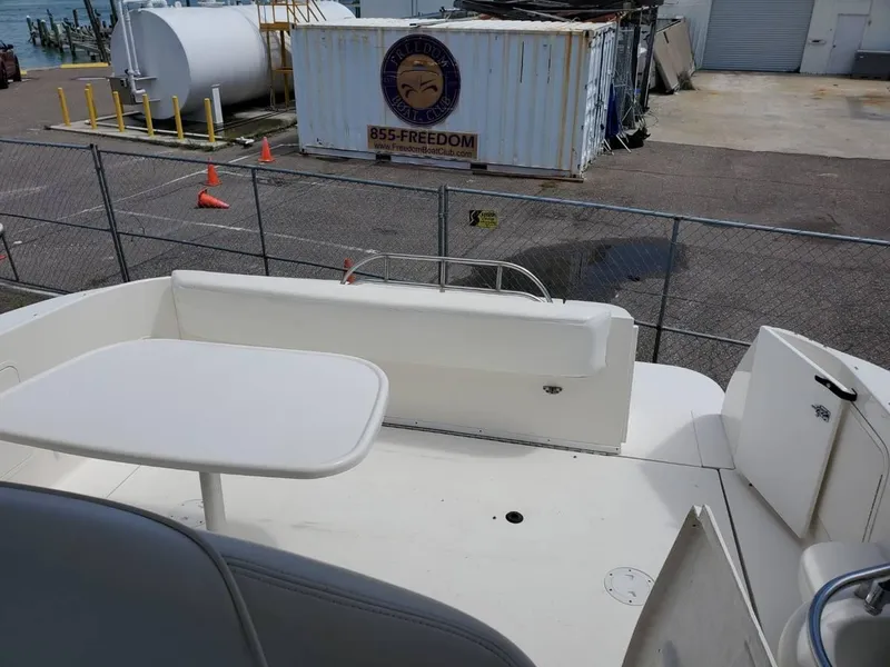 Slide: The Image of 2002 Sea Ray 310 Sundancer boat deck with seating and table, dockside view. - 22