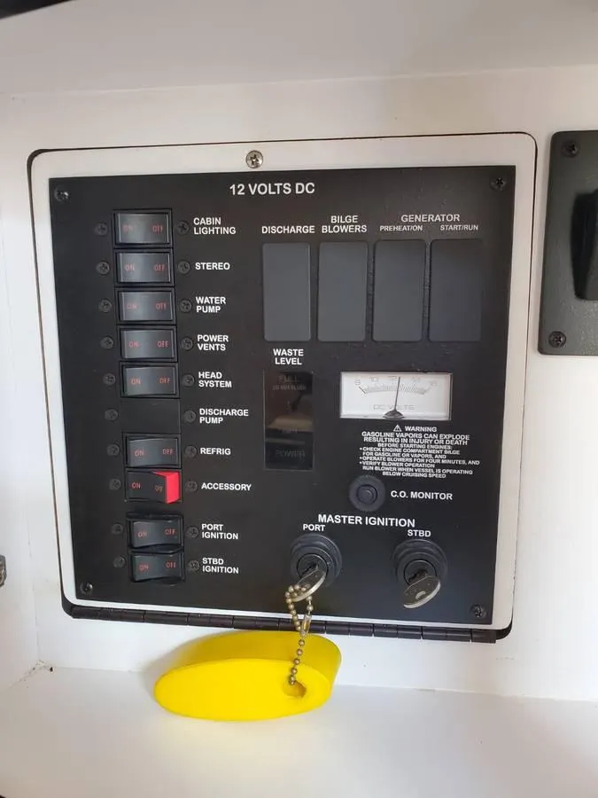 Slide: The Image of Control panel of a 2002 Sea Ray 310 Sundancer boat, featuring various switches and gauges. - 23
