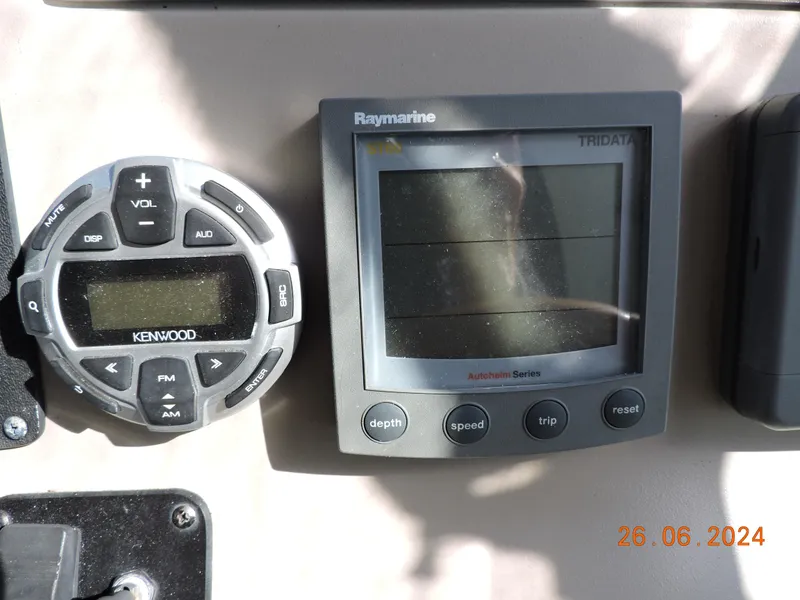 Slide: The Image of Kenwood and Raymarine displays on 2002 Sea Ray 310 Sundancer boat dashboard. - 25