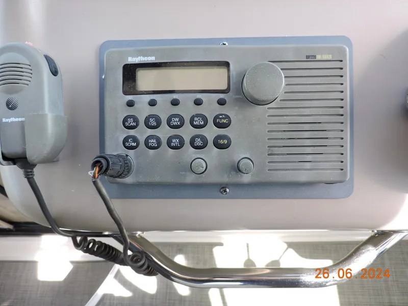 Slide: The Image of Raytheon marine radio on 2002 Sea Ray 310 Sundancer dashboard, dated June 26, 2024. - 26