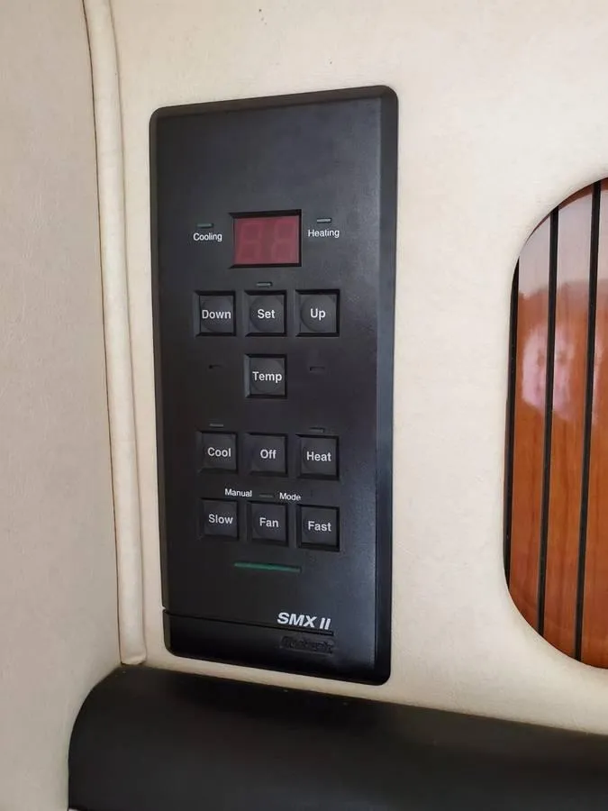 Slide: The Image of Control panel on a 2002 Sea Ray 310 Sundancer boat, featuring temperature and fan settings. - 32