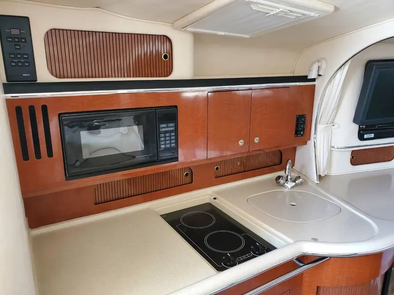Slide: The Image of 2002 Sea Ray 310 Sundancer galley with microwave, stove, and sink. - 35