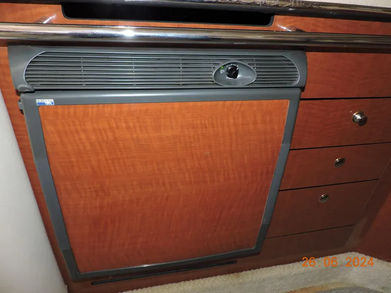 Slide: The Image of 2002 Sea Ray 310 Sundancer interior with wood paneling and built-in refrigerator. - 38