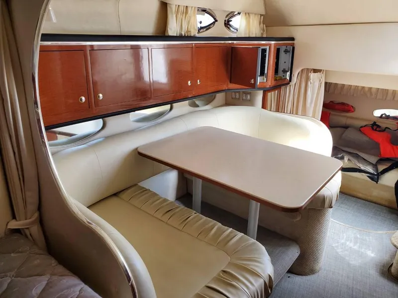 Slide: The Image of Interior of 2002 Sea Ray 310 Sundancer with dining area and wooden cabinets. - 39