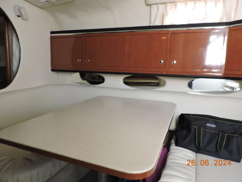 Slide: The Image of Interior of 2002 Sea Ray 310 Sundancer with dining area and wooden cabinets. - 40