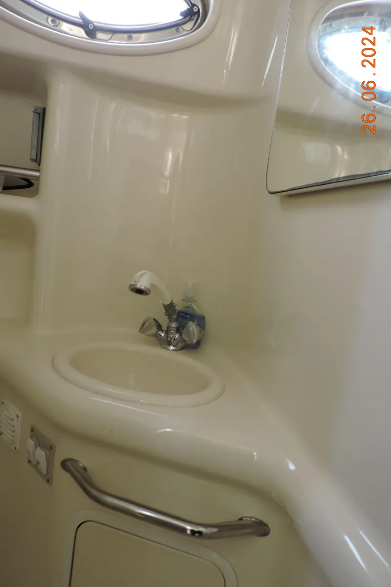 Slide: The Image of 2002 Sea Ray 310 Sundancer bathroom sink with mirror and porthole window. - 45