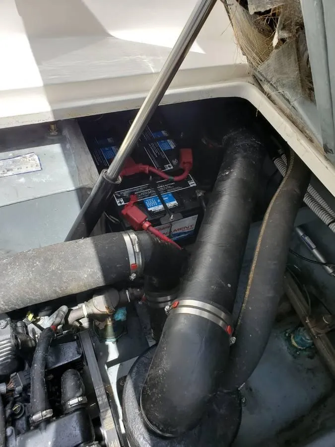 Slide: The Image of Engine compartment of a 2002 Sea Ray 310 Sundancer, showing battery and hoses. - 47