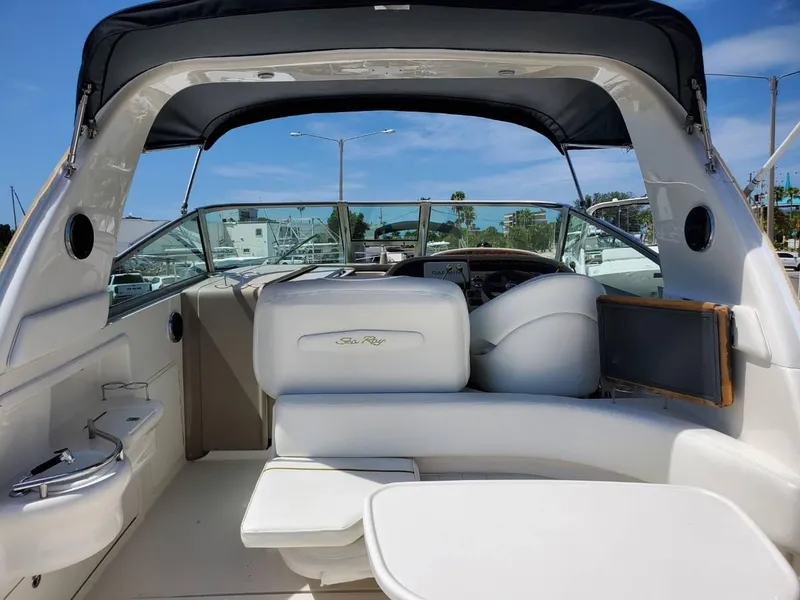 Slide: The Image of 2002 Sea Ray 310 Sundancer boat interior with seating and helm under canopy. - 6