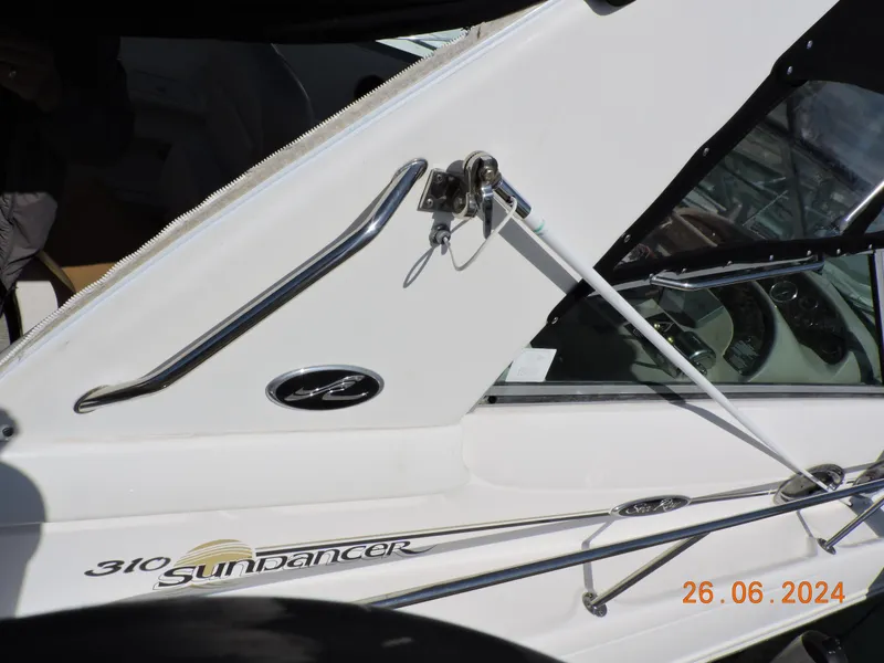 Slide: The Image of 2002 Sea Ray 310 Sundancer boat detail with logo and railing. - 9