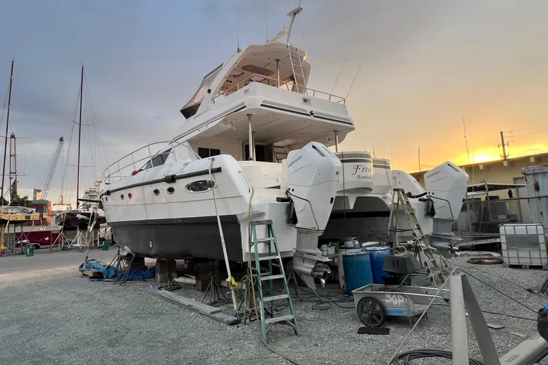 Slide: The Image of 2009 Africat Marine 420 yacht in dry dock at sunset, undergoing maintenance. - 12