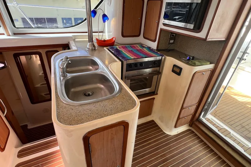 Slide: The Image of Kitchen area of a 2009 Africat Marine 420 yacht with sink, stove, and wooden cabinetry. - 23