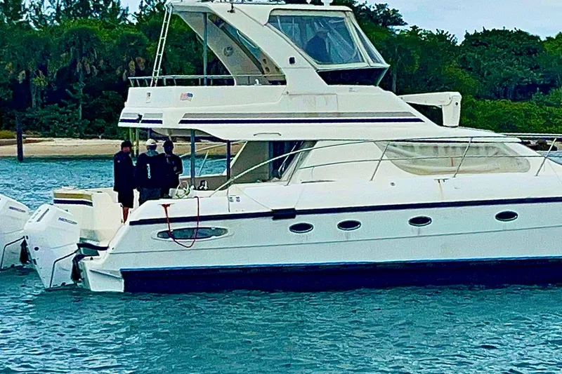 Slide: The Image of 2009 Africat Marine 420 yacht on water with people onboard, lush greenery in background. - 3