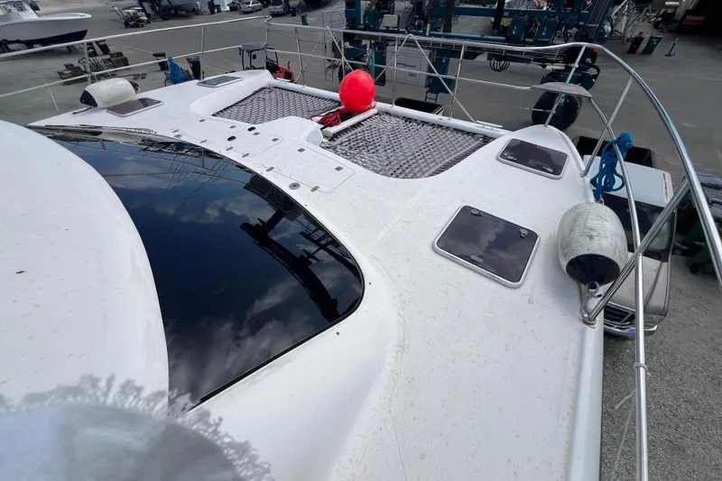 Slide: The Image of 2009 Africat Marine 420 yacht deck with hatches and safety equipment in a marina setting. - 46