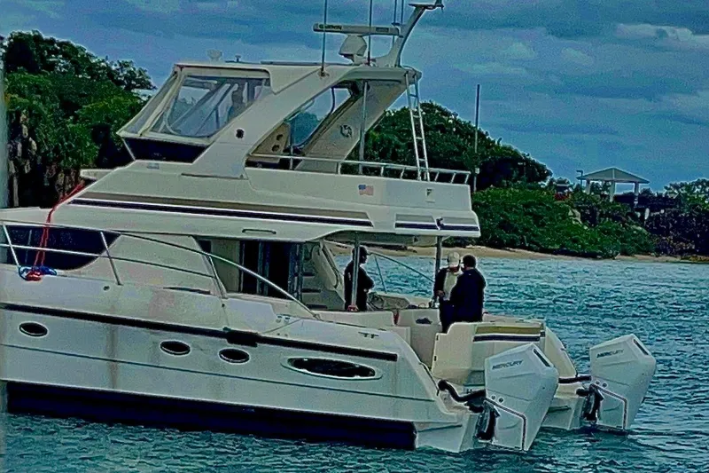 Slide: The Image of Luxury Africat Marine 420 yacht from 2009 on serene waters near lush greenery. - 7