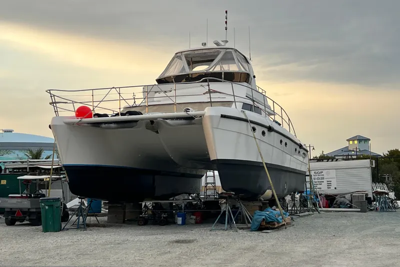 Slide: The Image of 2009 Africat Marine 420 catamaran on dry dock at sunset, ready for maintenance. - 8