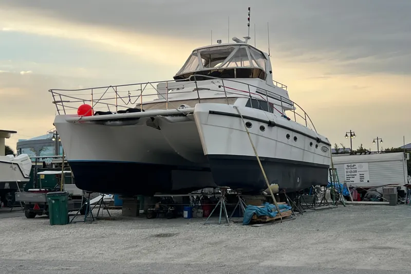 Slide: The Image of 2009 Africat Marine 420 catamaran on dry dock at sunset, ready for maintenance. - 9