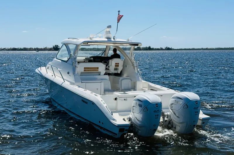 Slide: The Image of 2021 Pursuit OS 355 Offshore boat cruising on open water with twin Yamaha engines. - 10