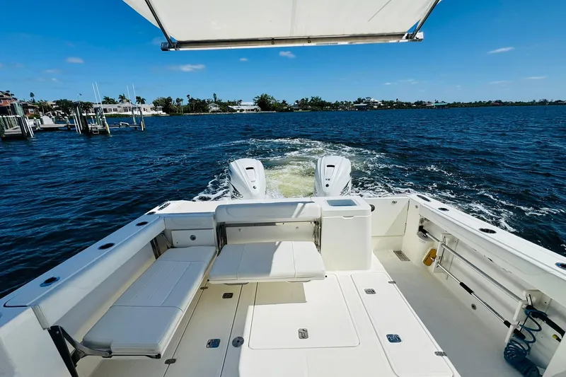 Slide: The Image of 2021 Pursuit OS 355 Offshore boat cruising on a sunny day, showcasing spacious deck. - 14