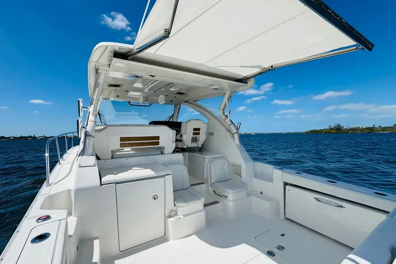 Slide: The Image of 2021 Pursuit OS 355 Offshore boat interior with open canopy on a sunny day. - 17