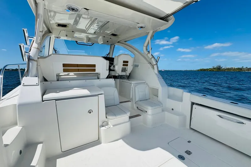 Slide: The Image of 2021 Pursuit OS 355 Offshore boat interior with seating, ocean view, and clear blue sky. - 18