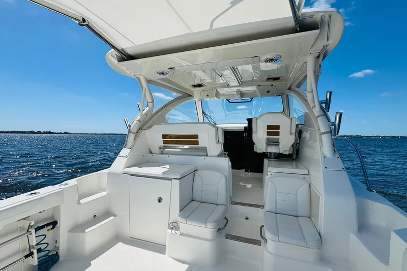 Slide: The Image of 2021 Pursuit OS 355 Offshore boat interior with seating, on a sunny day at sea. - 21