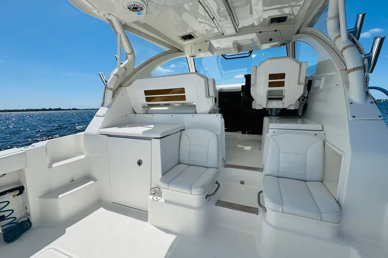 Slide: The Image of 2021 Pursuit OS 355 Offshore boat interior with white seating and ocean view. - 22