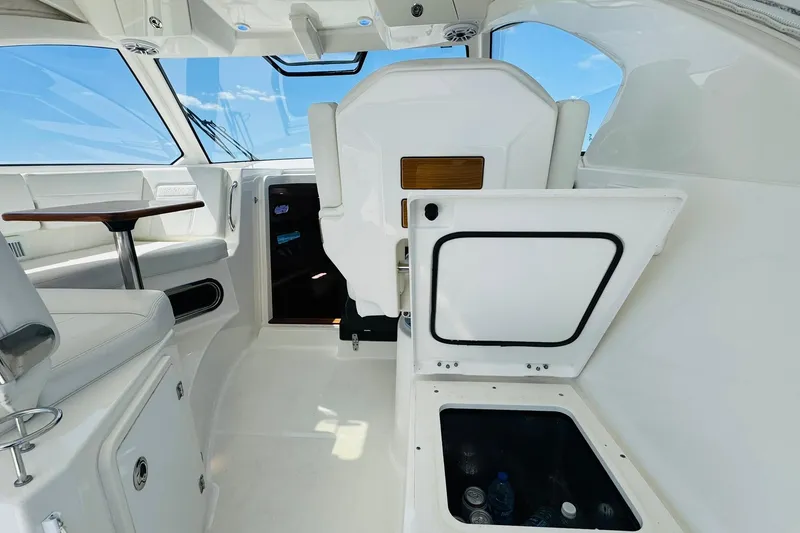 Slide: The Image of 2021 Pursuit OS 355 Offshore interior with seating, table, and storage compartment. - 24