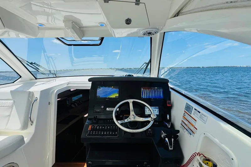 Slide: The Image of Helm of 2021 Pursuit OS 355 Offshore boat with navigation system, overlooking the ocean. - 28
