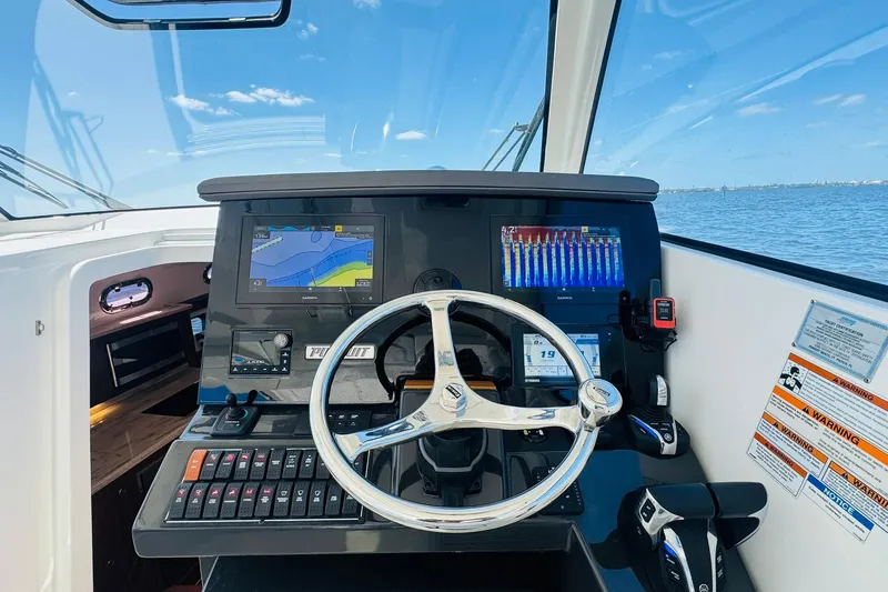 Slide: The Image of Helm of 2021 Pursuit OS 355 Offshore boat with navigation screens and controls. - 29