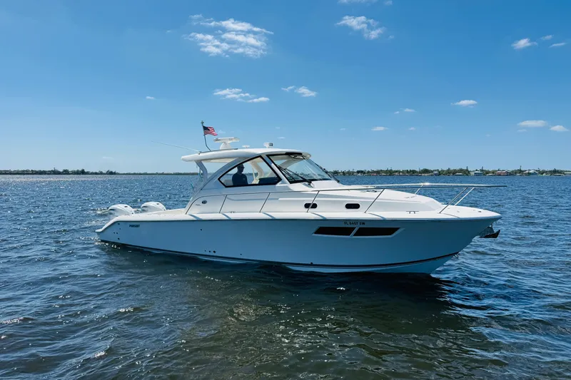 Slide: The Image of 2021 Pursuit OS 355 Offshore boat cruising on a sunny day with clear blue skies. - 3