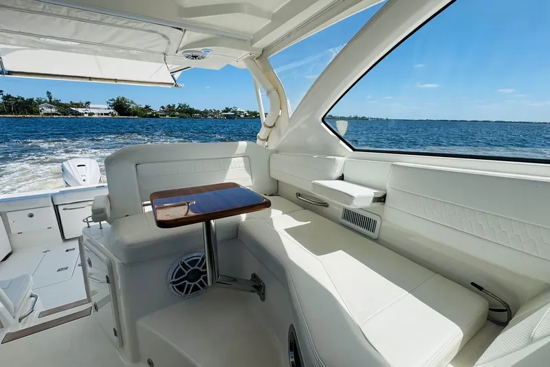 Slide: The Image of Interior of 2021 Pursuit OS 355 Offshore boat with white seating and ocean view. - 31