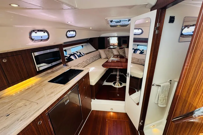 Slide: The Image of Luxurious interior of 2021 Pursuit OS 355 Offshore boat with modern kitchen and cozy seating area. - 34