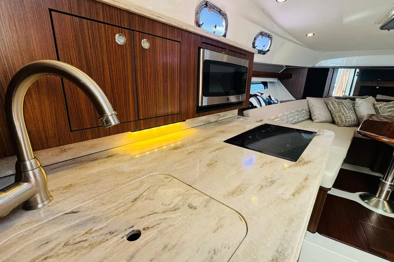 Slide: The Image of Luxurious 2021 Pursuit OS 355 Offshore yacht interior with modern kitchen and cozy seating area. - 37