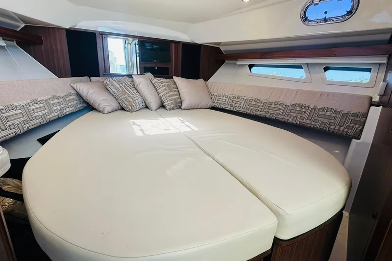 Slide: The Image of 2021 Pursuit OS 355 Offshore cabin with plush seating and decorative pillows. - 39