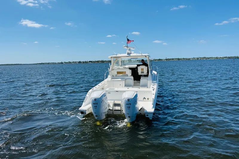 Slide: The Image of 2021 Pursuit OS 355 Offshore boat cruising on open water under clear blue sky. - 7