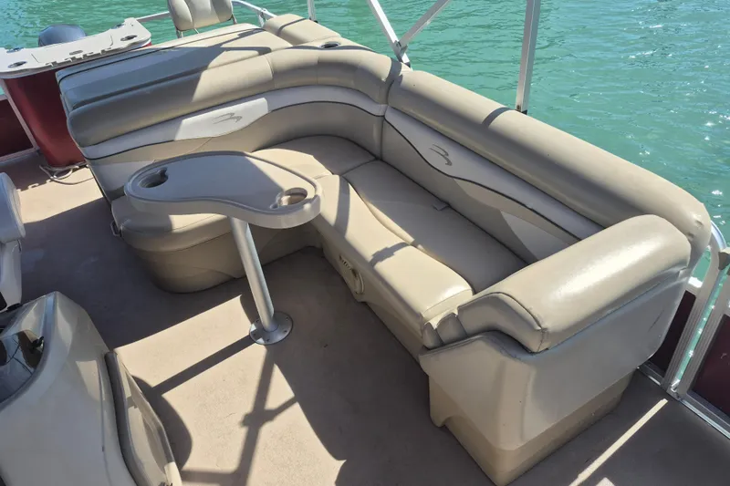 Slide: The Image of 2012 Bennington 22 SSI pontoon boat with beige seating and table on a sunny day. - 8