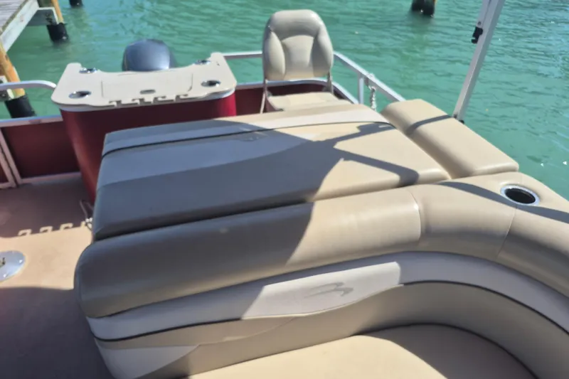 Slide: The Image of 2012 Bennington 22 SSI boat interior with beige seating and water backdrop. - 9
