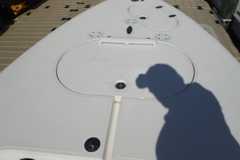 Slide: The Image of 2023 Lake & Bay 21 Boca Grande boat deck with motor, reflecting sunlight on water. - 14