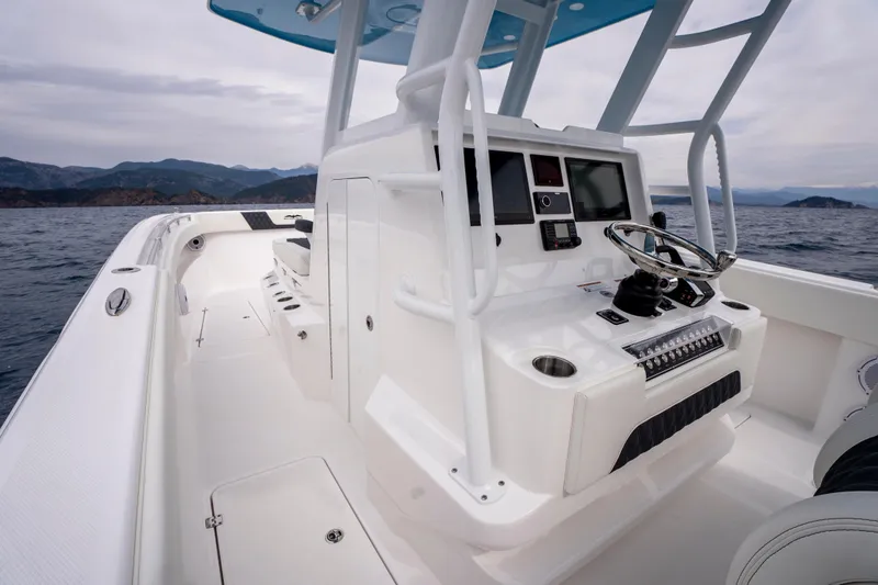 Slide: The Image of 2024 Invincible 33 Catamaran cockpit with modern controls, steering wheel, and ocean backdrop. - 15