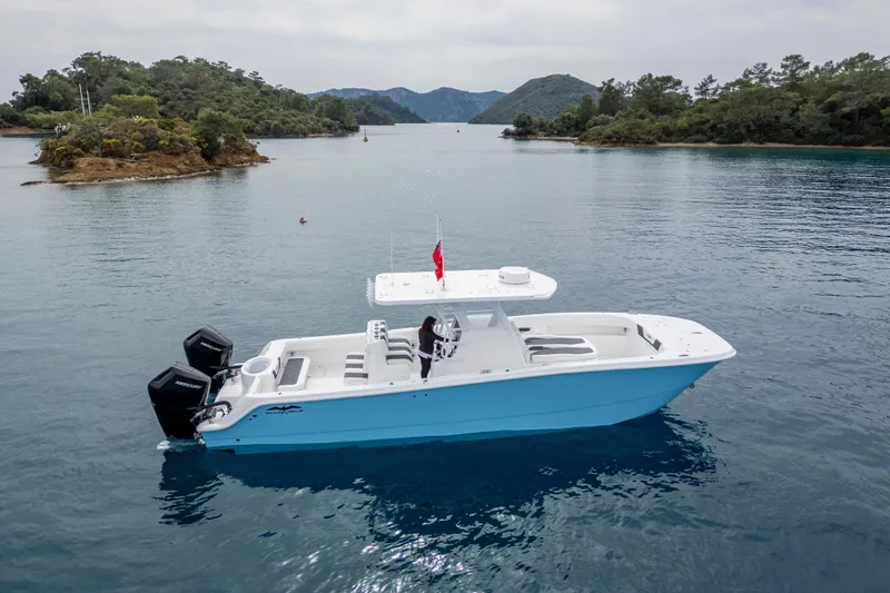 Slide: The Image of 2024 Invincible 33 Catamaran on calm waters, surrounded by green islands. - 2