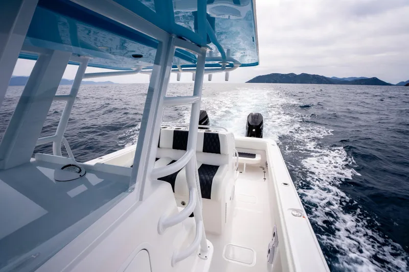 Slide: The Image of 2024 Invincible 33 Catamaran cruising on open sea with scenic island backdrop. - 22