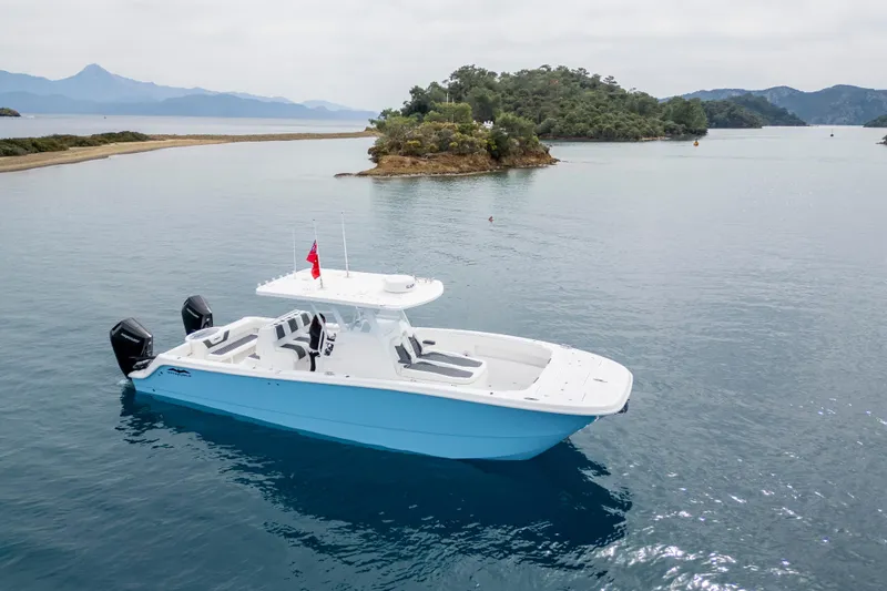 Slide: The Image of 2024 Invincible 33 Catamaran on serene waters near lush islands. - 5