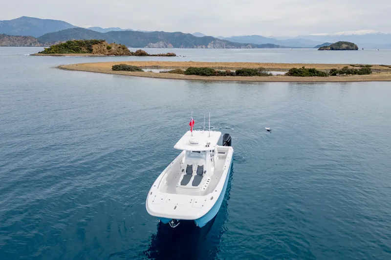Slide: The Image of 2024 Invincible 33 Catamaran cruising near scenic island landscape. - 7