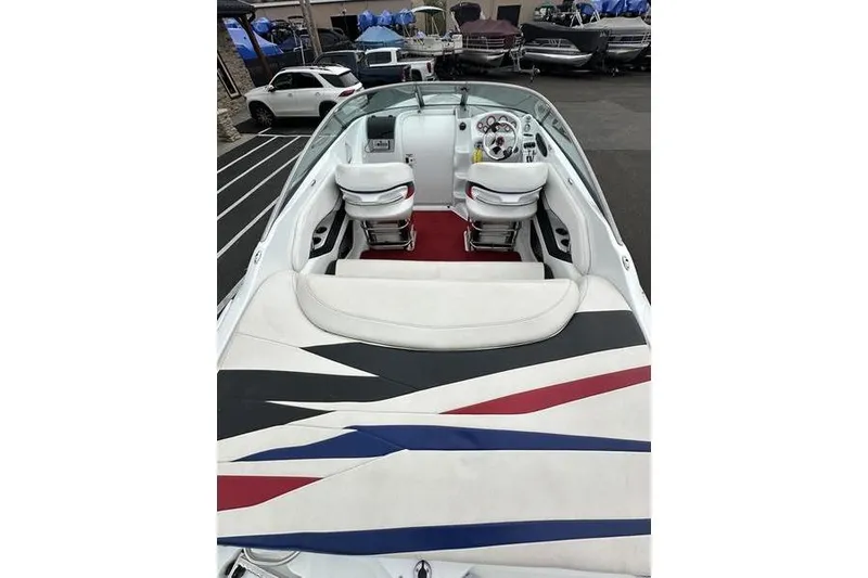 Slide: The Image of Custom 2006 245 Boss boat interior with white seats and colorful upholstery design. - 11