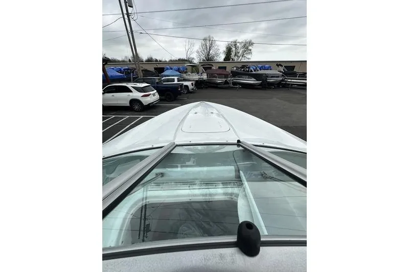 Slide: The Image of Custom 245 Boss boat, 2006 model, parked in a lot with other vehicles and boats. - 16