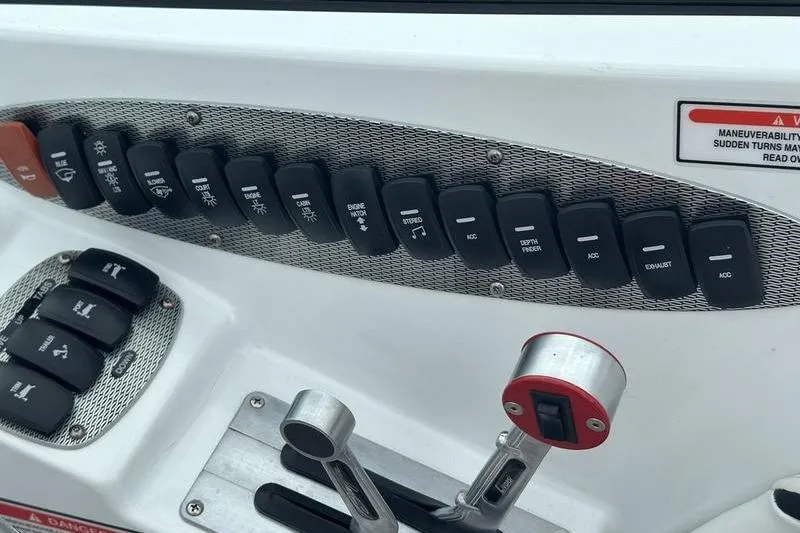 Slide: The Image of Control panel of a 2006 Custom 245 Boss boat with labeled switches and levers. - 2