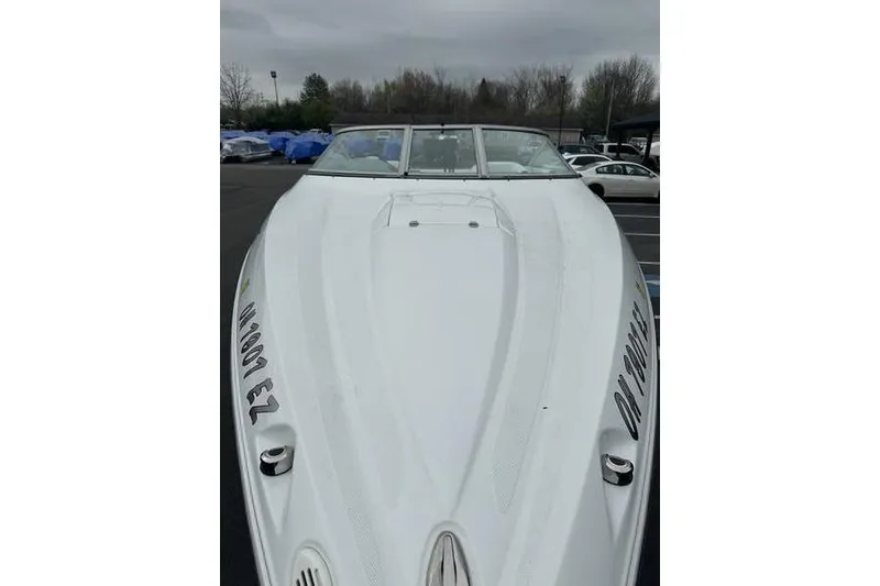 Slide: The Image of White 2006 Custom 245 Boss boat parked outdoors on a cloudy day. - 25