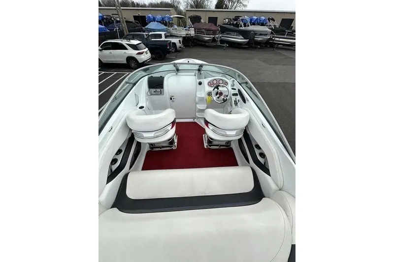 Slide: The Image of Interior of a 2006 Custom 245 Boss boat with white seating and red carpet. - 26