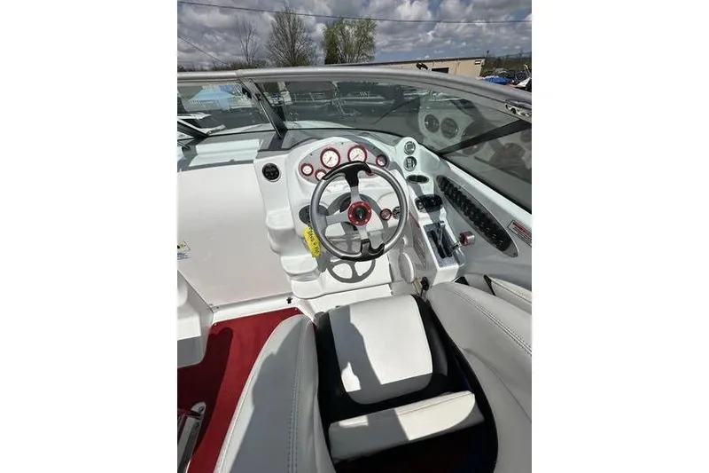 Slide: The Image of Interior of a 2006 Custom 245 Boss boat with steering wheel and dashboard controls. - 29
