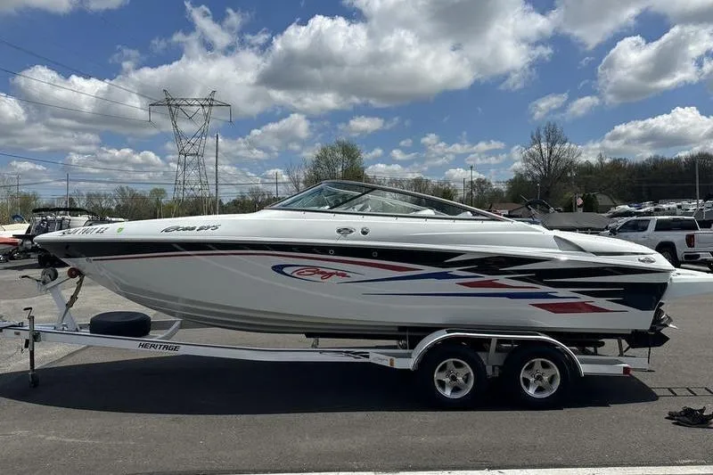 Slide: The Image of 2006 Custom 245 Boss boat on trailer under cloudy sky. - 30
